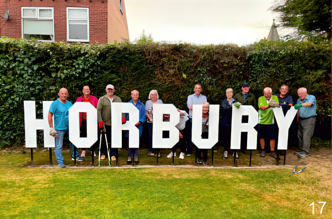 Group of Horbury residents standing in a green space, holding large white HORBURY letters