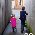 Two young children walking down an alleyway