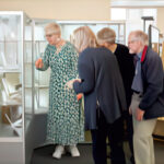 Group of local residents looking into a glass cabinet