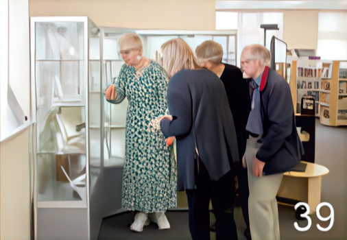 Group of local residents looking into a glass cabinet