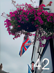 Hanging basket with pink flowers and Union Jack flag behind